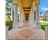 Covered walkway with classic columns and attractive pavers leading through lush landscaping, ideal for leisurely strolls at 13644 Brilliante Dr, Venice, FL 34293