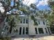 Modern home exterior featuring sleek windows, stucco, and mature trees at 1423 S Shade Ave, Sarasota, FL 34239