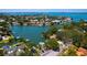An aerial view captures a residential neighborhood with waterfront homes, boats, and a tranquil bay, set against a sunny sky at 1542 Gulfview Dr, Sarasota, FL 34236