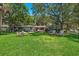 Expansive lawn with patio furniture, mature trees and lush landscaping at 1542 Gulfview Dr, Sarasota, FL 34236