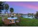 Picturesque waterfront backyard with lush green grass and a charming outdoor dining set for enjoying waterside meals at 1542 Gulfview Dr, Sarasota, FL 34236