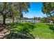 Lush backyard with mature trees, waterfront views, dining, and lounge seating, ideal for outdoor enjoyment at 1542 Gulfview Dr, Sarasota, FL 34236