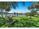 Lush backyard with mature trees, waterfront views, dining, and lounge seating, ideal for outdoor enjoyment at 1542 Gulfview Dr, Sarasota, FL 34236