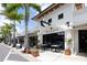 Charming commercial building featuring outdoor seating, lush landscaping, and inviting storefronts at 1542 Gulfview Dr, Sarasota, FL 34236