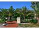 Landscaped park entrance with brick path, stone pillars, and lush greenery at 1542 Gulfview Dr, Sarasota, FL 34236