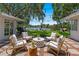 Cozy outdoor seating area on a brick patio with serene backyard and waterfront views at 1542 Gulfview Dr, Sarasota, FL 34236
