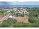 Picturesque aerial view showcases the neighborhood with lush greenery and waterfront views in the distance at 1613 6Th W St, Palmetto, FL 34221
