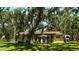Home back exterior with patio seating, large yard, and a privacy fence at 1613 6Th W St, Palmetto, FL 34221