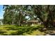 Home back exterior surrounded by shady, mature trees at 1613 6Th W St, Palmetto, FL 34221