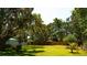 Large backyard with lush grass and mature trees offering plenty of shade and privacy at 1613 6Th W St, Palmetto, FL 34221