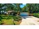 Charming single-story home featuring a well-manicured lawn, mature trees, and an attached garage at 1613 6Th W St, Palmetto, FL 34221
