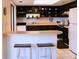 Well-lit kitchen featuring dark wood cabinetry, stainless steel appliances, and bar seating for casual dining at 1613 6Th W St, Palmetto, FL 34221