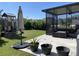 Outdoor living space with seating area, umbrella, potted plants, playset and well-kept lawn at 16919 Trite Bend St, Wimauma, FL 33598