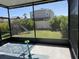 View of the backyard through a screened-in porch featuring a playset and well-maintained lawn at 16919 Trite Bend St, Wimauma, FL 33598