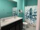 Bright bathroom featuring a dual sink vanity with a quirky octopus themed shower curtain and blue walls at 16919 Trite Bend St, Wimauma, FL 33598