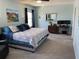 Bright primary bedroom with a king bed, dual windows, and a work space featuring dual monitors at 16919 Trite Bend St, Wimauma, FL 33598
