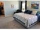 Spacious primary bedroom featuring a comfortable reading chair, large windows and a painting above the bed at 16919 Trite Bend St, Wimauma, FL 33598