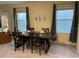 Traditional dining room with a dark wood table, seating for six, and view to the backyard at 16919 Trite Bend St, Wimauma, FL 33598