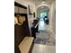 Inviting entryway with coat rack, bench, piano, and views of the dining room and living area at 16919 Trite Bend St, Wimauma, FL 33598