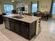Kitchen island with sink and stainless steel appliances leading into a dining room and living area at 16919 Trite Bend St, Wimauma, FL 33598