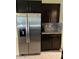 Modern kitchen features stainless steel refrigerator and dark cabinetry at 16919 Trite Bend St, Wimauma, FL 33598
