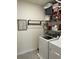 Well-organized laundry room with front load washer and dryer, shelving and hanging rack at 16919 Trite Bend St, Wimauma, FL 33598