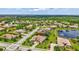 An elevated aerial view of a neighborhood with homes, lawns, landscaping, and a tranquil lake at 17003 2Nd E Ave, Bradenton, FL 34212