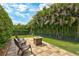 Outdoor patio area with seating and a fire pit, surrounded by lush landscaping for private relaxation and entertaining at 17003 2Nd E Ave, Bradenton, FL 34212