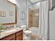 Bathroom featuring a wood vanity, a framed mirror, and a shower with a tile surround at 17003 2Nd E Ave, Bradenton, FL 34212