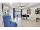 Inviting living room with a grand piano, stylish blue armchairs, and a ceiling fan at 17003 2Nd E Ave, Bradenton, FL 34212