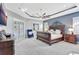 Main bedroom with a large bed, blue accent chair, and sliding doors that lead to an outdoor space at 17003 2Nd E Ave, Bradenton, FL 34212