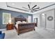 Elegant main bedroom showcasing a large bed with stylish blue accent wall and tray ceiling with fan at 17003 2Nd E Ave, Bradenton, FL 34212