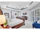 Bright main bedroom with a large bed, a ceiling fan, and neutral décor with a TV mounted on the wall at 17003 2Nd E Ave, Bradenton, FL 34212
