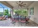 Screened outdoor dining area with grill and ceiling fan overlooking a serene backyard at 17003 2Nd E Ave, Bradenton, FL 34212