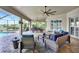 Covered outdoor patio with lounge seating, ceiling fans, a dining area, and screened-in pool at 17003 2Nd E Ave, Bradenton, FL 34212