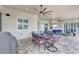 Covered outdoor patio featuring a dining area, lounge furniture, and ceiling fans for comfortable entertaining at 17003 2Nd E Ave, Bradenton, FL 34212