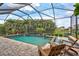 Inviting pool and spa with a screened enclosure and comfortable lounge chairs for sunbathing at 17003 2Nd E Ave, Bradenton, FL 34212