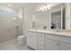 Well-lit bathroom with double sinks, stone countertops, and a walk-in shower at 17640 Northwood Pl, Bradenton, FL 34202