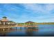 Picturesque lake view featuring a covered pier and clubhouse, creating a serene and inviting atmosphere at 17640 Northwood Pl, Bradenton, FL 34202
