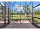Screened lanai overlooking a lush green yard with palm trees and a brick-paved deck at 17640 Northwood Pl, Bradenton, FL 34202