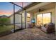 Relaxing covered patio features brick flooring, outdoor seating, TV, and a screened-in area at 17640 Northwood Pl, Bradenton, FL 34202