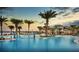 Serene pool area with palm trees, sun loungers, and a view of the community buildings at 17640 Northwood Pl, Bradenton, FL 34202