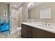 Updated bathroom with a walk-in shower, dual sink vanity, and wood-look flooring at 1951 San Silvestro Dr, Venice, FL 34285