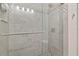 Elegant bathroom shower features decorative tile, glass door, and modern shower head at 1951 San Silvestro Dr, Venice, FL 34285