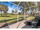 This screened lanai features beautiful views of the lush green golf course and outdoor lounge chairs at 1951 San Silvestro Dr, Venice, FL 34285