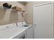Functional laundry room with modern washer and dryer, plus convenient storage shelves at 1951 San Silvestro Dr, Venice, FL 34285