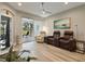 Living room featuring wood-look flooring, a ceiling fan, and sliding glass doors that lead to the outdoor space at 1951 San Silvestro Dr, Venice, FL 34285