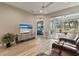 Cozy living room with a leather reclining sofa, mounted television, and sliding glass doors to the outside at 1951 San Silvestro Dr, Venice, FL 34285