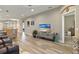 Open-concept living area featuring wood-look flooring, a wall-mounted television, and comfortable seating at 1951 San Silvestro Dr, Venice, FL 34285