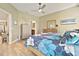 Main bedroom with wood-look floors, a ceiling fan, and access to both the walk-in closet and the en suite at 1951 San Silvestro Dr, Venice, FL 34285